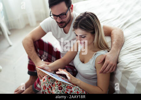 Giovane coppia attraente con tavoletta digitale in camera da letto Foto Stock