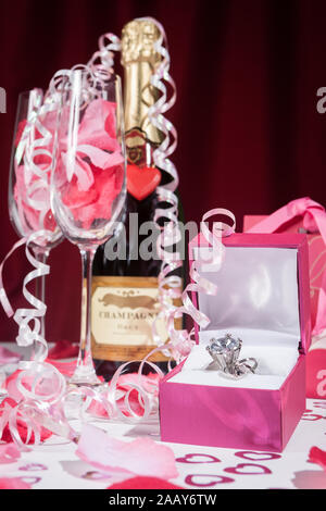 Amore e San Valentino: Un diamante anello di fidanzamento, una bottiglia di champagne e bicchieri per due. Foto Stock