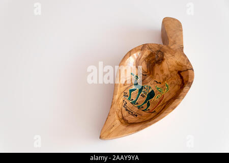 In legno di olivo ciotola dalla Tunisia nella forma di una foglia decorativa con un cammello disegnata su uno sfondo bianco. La Tunisia, Africa Foto Stock