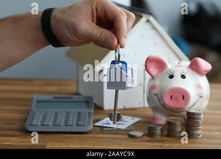 Calcolatrice con salvadanaio contro home contesto Foto Stock