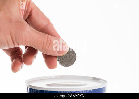 Maschio lato mettendo una moneta nella lattina può salvare banca. Cinque kopecks della grivna. Foto Stock