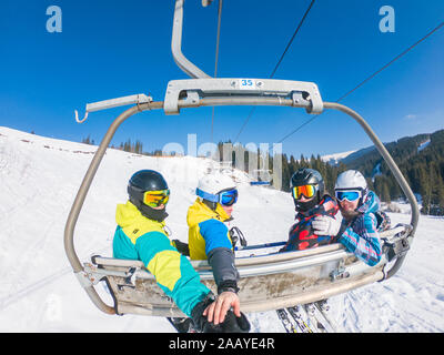 Gli amici di ski lift tenendo selfie Foto Stock