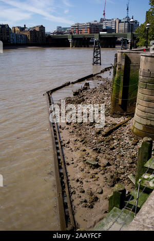 Un paesaggio urbano guardando verso Southwick ponte ferroviario lungo il fiume Tamigi a Londra Inghilterra che mostra il Tamigi a bassa marea accanto alla passeggiata anseatica Foto Stock