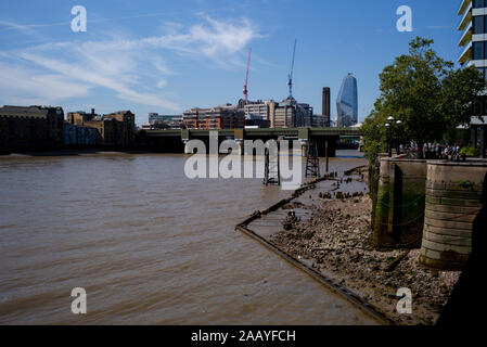 Un paesaggio urbano guardando verso Southwick ponte ferroviario lungo il fiume Tamigi a Londra Inghilterra che mostra il Tamigi a bassa marea accanto alla passeggiata anseatica Foto Stock