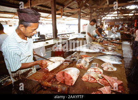 Ndonesia. Sulawesi. Lago Poso regione. Pendolo mercato del pesce. Pescivendolo il taglio di pesce. Foto Stock