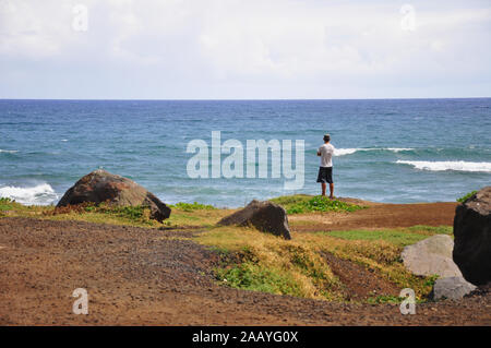 Uomo in piedi alla scogliera di Mokuleia Beach Park, Kaena Point presso la North Shore di Oahu Island, Hawaii, Stati Uniti. Foto Stock