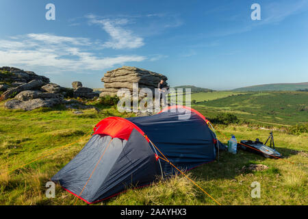 Padre e figlio campeggio selvaggio su Dartmoor durante l'estate. Foto Stock