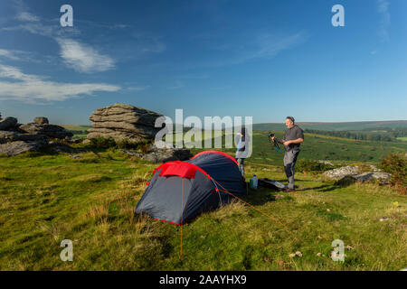 Padre e figlio campeggio selvaggio su Dartmoor durante l'estate. Foto Stock