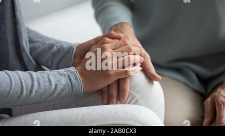 Figlia cresciuto tenendo la mano delle madri che mostra il supporto closeup immagine Foto Stock