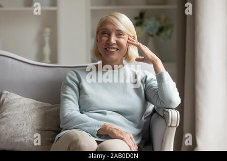 Età positivo donna seduta sul divano guardando la fotocamera in luoghi chiusi Foto Stock
