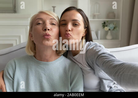 Madre e figlia cresciuto in posa rendendo selfie vista webcam Foto Stock