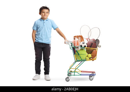 A piena lunghezza Ritratto di un ragazzo con un pallone da calcio, rugby ball, palla da tennis e basket in un carrello shoping isolati su sfondo bianco Foto Stock