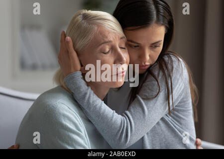 Mom condividere problemi figlia adulta abbracci lenisce il suo mostrare compassione Foto Stock