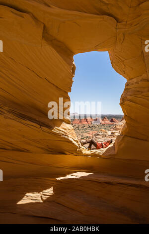 Giovane escursionista fermarsi a riposare o dormire sotto il sole al di sotto e arco nel deserto dell'Arizona di Coyote Buttes North deserto. Foto Stock