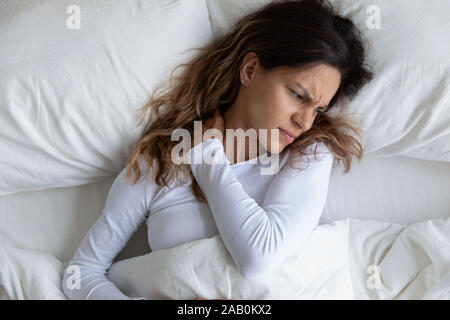 Vista sopra un cipiglio donna si sente dolore al collo Foto Stock