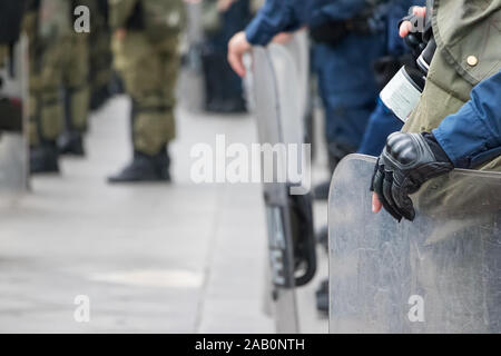 Maschio di polizia antisommossa tenendo la sua protezione con la sua mano. Foto Stock