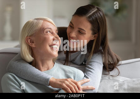 Cresciuto figlia abbracciando madre anziana ridere a divertirsi insieme Foto Stock