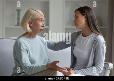 Figlia cresciuto tenendo la mano della madre anziana dando il suo supporto Foto Stock