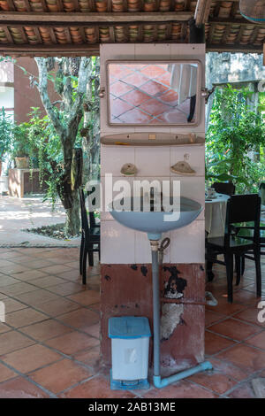 In Cai Be, Mekong Deltal, Vietnam - Marzo 13, 2019: lavare a mano tavolo con specchio in sala da pranzo con i lati aperti del sig. Kiet storica casa di famiglia. Il GRE Foto Stock