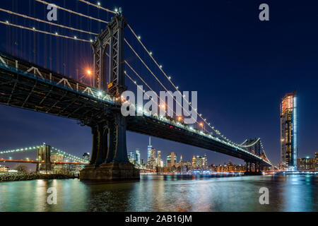 Vista notturna di Manhattan dal ponte di Brooklyn Main Street Park con grattacieli di Manhattan in background. New York City, NY, STATI UNITI D'AMERICA Foto Stock