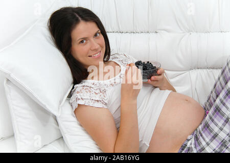 Foto di donna incinta con mirtilli Foto Stock