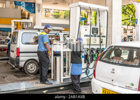 Bangalore, India, strade della citta' di Bengaluru, gas locale stazione di benzina i dipendenti Foto Stock