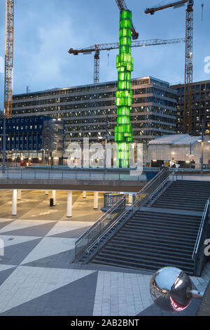 Obelisco di vetro illuminato in verde all'alba e il Sunken Plaza, Sergels Torg, Stoccolma, Svezia Foto Stock