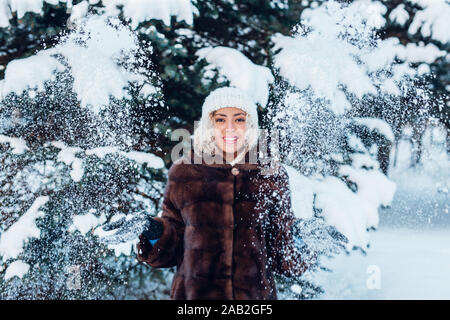 Felice giovane donna afro giocando con la neve in inverno park Foto Stock