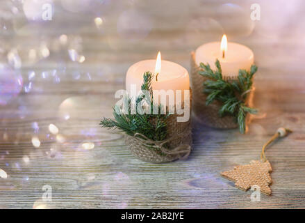 Sfondo di Natale con le candele. In legno, sfondo bokeh, il fuoco selettivo. Close up. Foto Stock