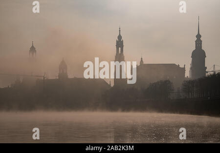 Dresden, Germania. 25 Nov, 2019. Al mattino, nebbia mattutina si diffonde oltre il centro storico della città sull'Elba con la Frauenkirche, la Ständehaus, la Hofkirche e il Hausmannsturm. Credito: Robert Michael/dpa-Zentralbild/dpa/Alamy Live News Foto Stock