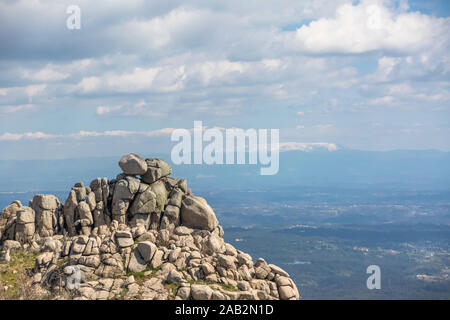 Vista dalla cima del Caramulo montagne oltre i Estrela montagne, rocce granitiche e macchia mediterranea in Portogallo Foto Stock