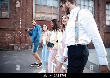 Gruppo di felice giovani amici divertendosi sulla strada di città Foto Stock