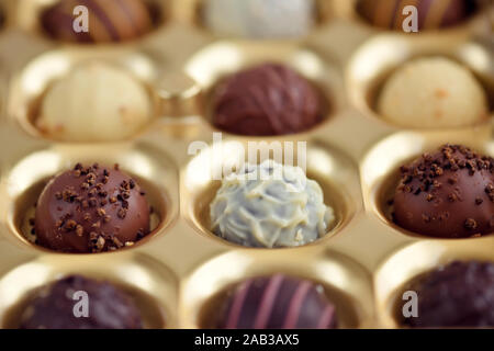 Un assortimento di cioccolatini in oro confezione regalo. Messa a fuoco selettiva Foto Stock