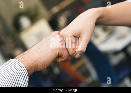 Maschio e femmina a urtare i pugni in ufficio, close up Foto Stock