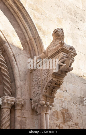 Un dettaglio di un leone e una figura umana statua della Cattedrale di San Marco presso il comune di Isola di Korcula, Dalmazia, Croazia. Bellissimi elementi gotici. Foto Stock