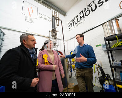 Leith, Scotland, Regno Unito. Il 25 novembre 2019. Scottish liberal democratici campagna sedia Alex Cole-Hamilton e Rebecca campana parlamentare liberale candidato per Dunfermline e West Fife visitato porto di Leith distilleria e delineato i piani partyÕs al bersaglio nuovo terreno come Edimburgo nord e Leith, così come ritrovare il tradizionale partyÕs Scozia meridionale nello snap elezione generale. Nella foto. Ian Stirling di Leith Distillery spiega il processo di distillazione. Iain Masterton/Alamy Live News. Foto Stock