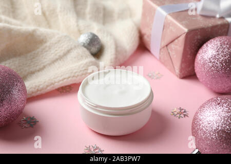 Vasetto di inverno la crema per la pelle, natale giocattolo, confezione regalo su sfondo rosa, spazio per il testo Foto Stock