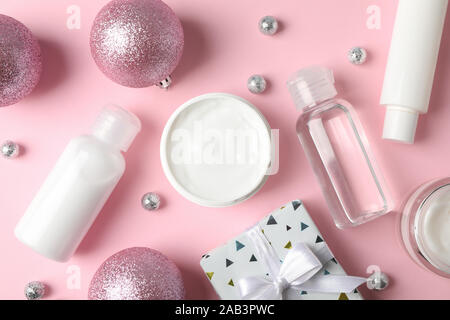 Impostare i cosmetici, inverno la crema per la pelle, confezione regalo su sfondo rosa, primo piano. Vista superiore Foto Stock