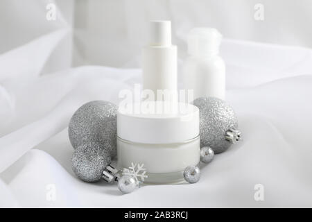 Impostare i cosmetici, un vasetto di crema invernale per la pelle sul tessuto bianco di sfondo, closeup. Spazio per il testo Foto Stock