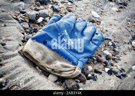 Angespülter Arbeitshandschuh am Strand von Travemünde |alluvionali guanto di lavoro sulla spiaggia di Travemünde| Foto Stock