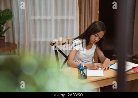 Asian teenager fare i compiti a casa Foto Stock