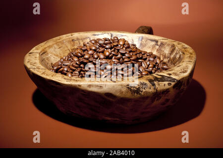 Holzschale mit frisch geroestete Kaffeebohnen |ciotola di legno di fresco con chicchi di caffè tostati| Foto Stock