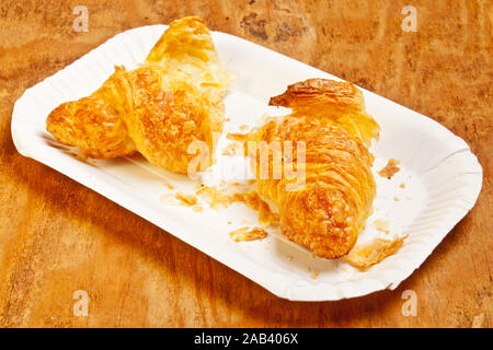 Ein zerteiltes Croissant auf einer Kuchenpappe |un cornetto diviso su una torta di cartone| Foto Stock