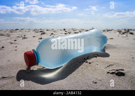 Eine angespülte Mineralwasserflasche aus Kunststoff auf einer Sandbank im watt |alluvionale una bottiglia di acqua minerale di plastica su un banco di sabbia in borra Foto Stock