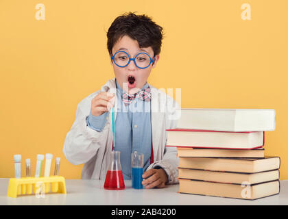 Bambino scienziato in laboratorio su sfondo giallo Foto Stock