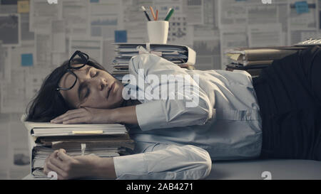 Esaurito oberati di lavoro imprenditrice dormire sulla scrivania, ella è sovraccarico di lavoro Foto Stock