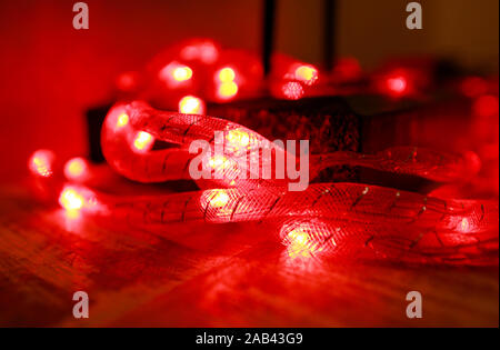 Rosso brillante Anno nuovo Natale Luci di riso, profondità di campo. Abstract luce rossa sullo sfondo. Decorative luci lampeggianti, ornamenti per natale. Foto Stock