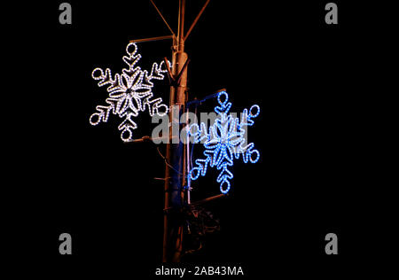 Il Natale di colore blu e luci bianche che simulano la forma di congelati Fiocchi di neve. Street dettaglio del nuovo anno e le decorazioni di Natale, stringa di riso lampadine delle luci. Foto Stock