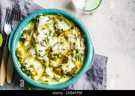 Broccoli casseruola con formaggio nel piatto blu, sfondo grigio. Vegetariano cibo sano concetto. Foto Stock