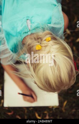 Bambino biondo per la scrittura di lettere Foto Stock